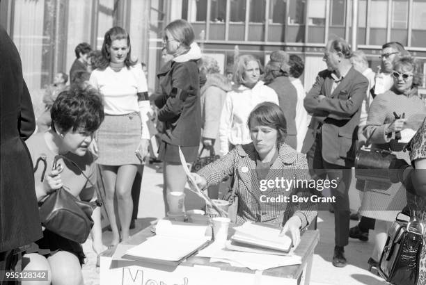 Outside the Time Life Building during the Moratorium to End the War in Vietnam demonstration, a woman with a black armband over her blazer sits at a...