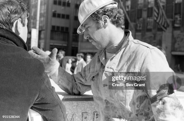 Close-up of two men as they talk together outside the Time Life Building during the Moratorium to End the War in Vietnam demonstration, New York, New...