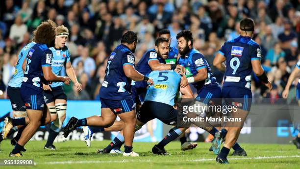 Blues players tackle Rob Simmons of the Waratahs during the round 12 Super Rugby match between the Waratahs and the Blues at Lottoland on May 5, 2018...