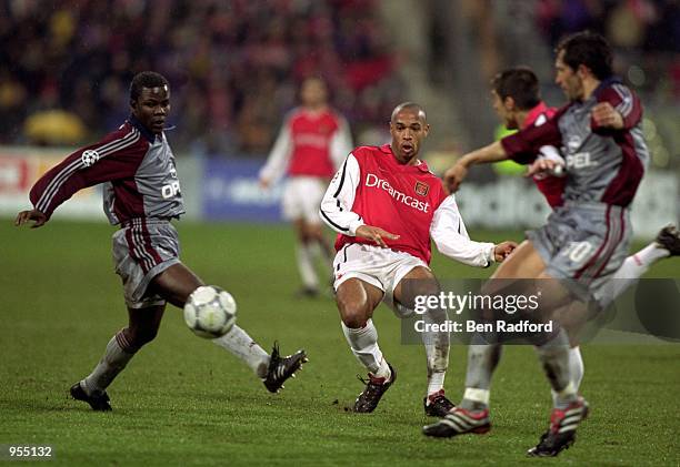 Thierry Henry of Arsenal plays the ball past Samuel Kuffour of Bayern Munich during the UEFA Champions League Group C match at the Olympiastadion in...