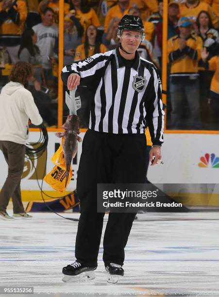 Linesman Ryan Gibbons#58 picks up a catfish prior to a game between the Nashville Predators and the Winnipeg Jets during the first period of Game...