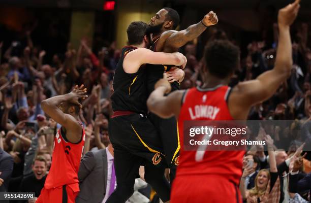 LeBron James of the Cleveland Cavaliers celebrates his game winning shot with Kevin Love behind Kyle Lowry of the Toronto Raptors during Game Three...