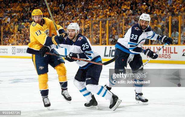 Nick Bonino of the Nashville Predators battles against Paul Stastny and Dustin Byfuglien of the Winnipeg Jets in Game Five of the Western Conference...