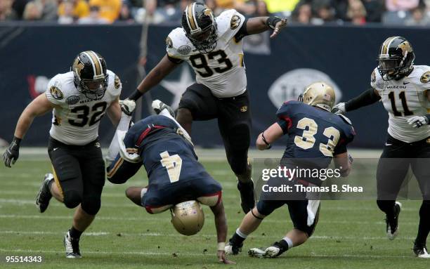 Defensive lineman Terrell Resonno of the Missouri Tigers trips quarterback Ricky Dobbs of the Navy Shipmen fumbles the ball over the goal line during...