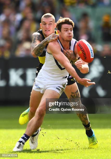 Lachie Neale of the Dockers handballs whilst being tackled by Dustin Martin of the Tigers during the round seven AFL match between the Richmond...