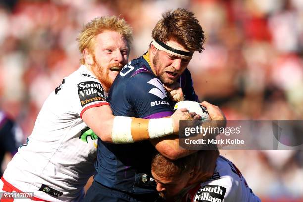 Christian Welch of the Storm is tackled by James Graham and Jack De Belin of the Dragons during the round nine NRL match between the St George...