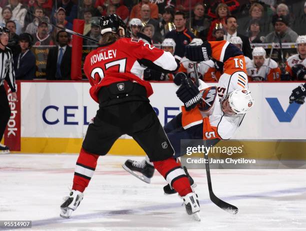 Alexei Kovalev of the Ottawa Senators checks Frans Nielsen the New York Islanders at Scotiabank Place on December 31, 2009 in Ottawa, Ontario, Canada.