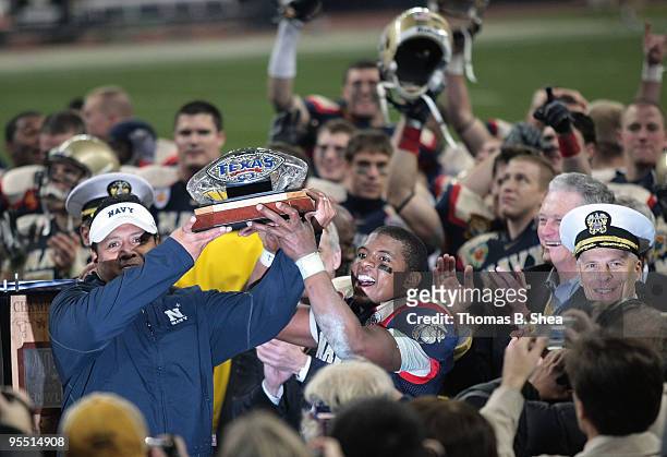 Head coach Ken Niumatalolo and quarterback Ricky Dobbs of the Navy Shipmen hold up the Texas Bowl trophy after the Texas Bowl at Reliant Stadium on...