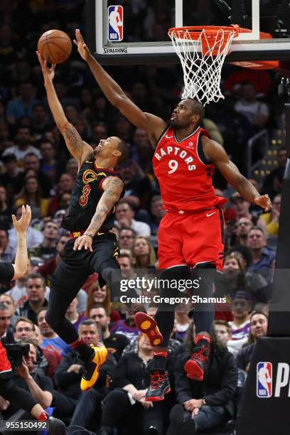 George Hill of the Cleveland Cavaliers tries to get a second half shot off past Serge Ibaka of the Toronto Raptors during Game Three of the Eastern...