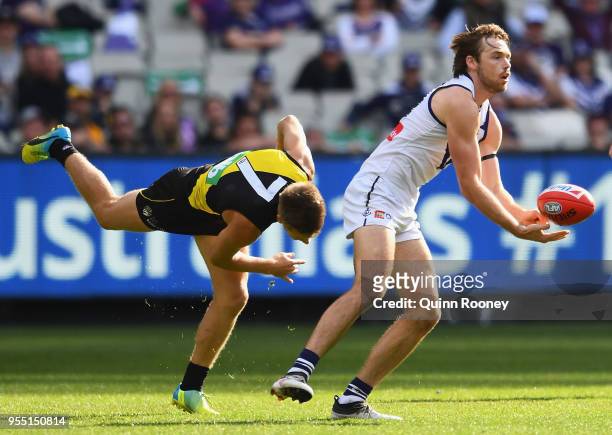 Joel Hamling of the Dockers handballs whilst being tackled by Dan Butler of the Tigers during the round seven AFL match between the Richmond Tigers...