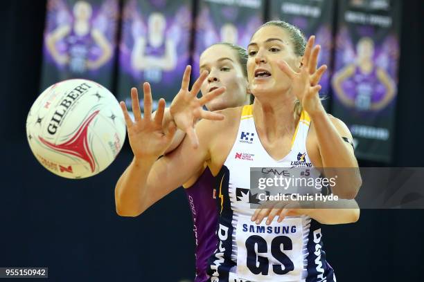 Tara Hinchliffe of the Firebirds and Caitlin Bassett of the Lightning compete for the ball during the round two Super Netball match between the...