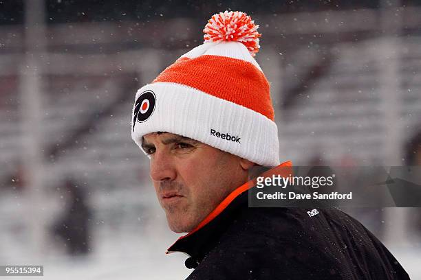 Head coach Peter Laviolette of the Philadelphia Flyers looks on during practice prior to Bridgestone's presentation of 2010 NHL Winter Classic at...