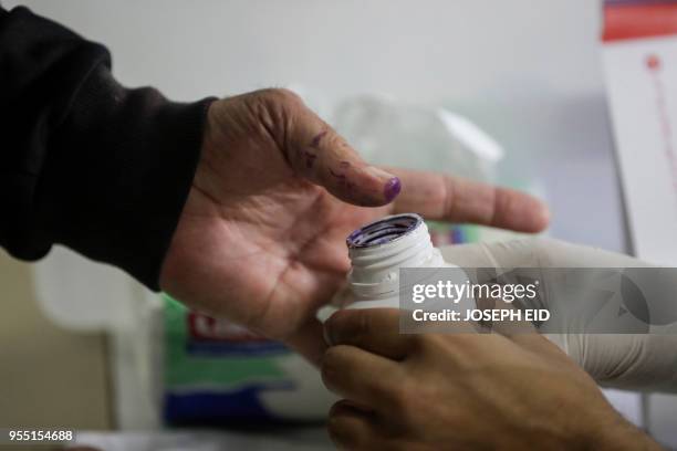 Lebanese man dips his thumb in voting ink after casting his vote in the first parliamentary election in nine years, in the coastal city of Byblos,...