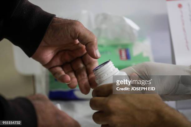 Lebanese man dips his thumb in voting ink after casting his vote in the first parliamentary election in nine years, in the coastal city of Byblos,...
