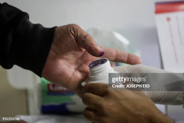 Lebanese man dips his thumb in voting ink after casting his vote in the first parliamentary election in nine years, in the coastal city of Byblos,...