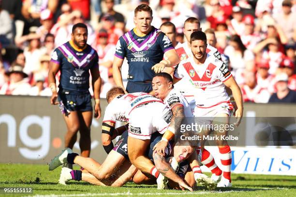 Cameron Munster of the Storm is tackled short of the try line during the round nine NRL match between the St George Illawarra Dragons and the...
