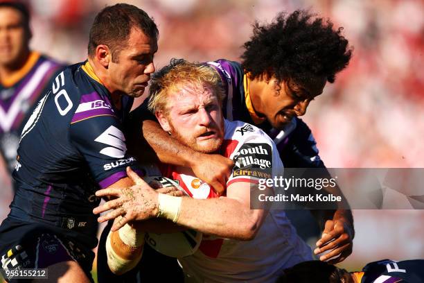 James Graham of the Dragons is tackled byt Cameron Smith and Felise Kaufusi of the Storm during the round nine NRL match between the St George...