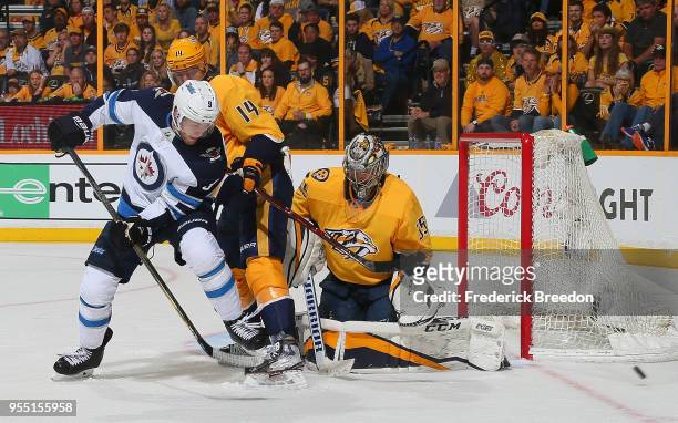 Andrew Copp of the Winnipeg Jets shoots the puck wide of Mattias Ekholm and Pekka Rinne of the Nashville Predators during the second period of Game...