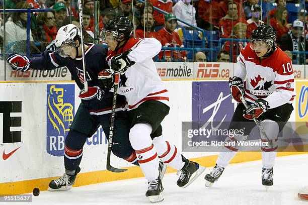 Travis Hamonic of Team Canada body checks Danny Kristo of Team USA during the 2010 IIHF World Junior Championship Tournament game on December 31,...