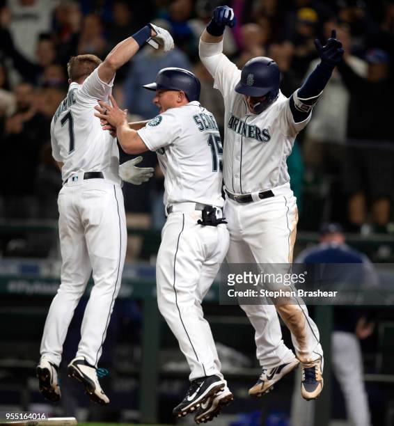 Andrew Romine, Kyle Seager, and Mike Zunino celebrate after Seager scored the winning run on a single by Ryon Healy of the Seattle Mariners off of...