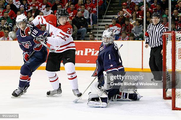 Jack Campbell of Team USA lets in a goal in front of Luke Adam of Team Canada and Brain Lashoff during the 2010 IIHF World Junior Championship...