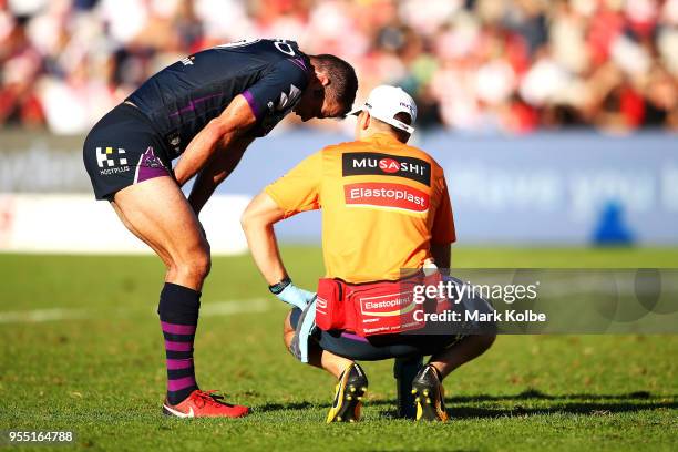 Cameron Smith of the Storm receives attention from the trainer during the round nine NRL match between the St George Illawarra Dragons and the...