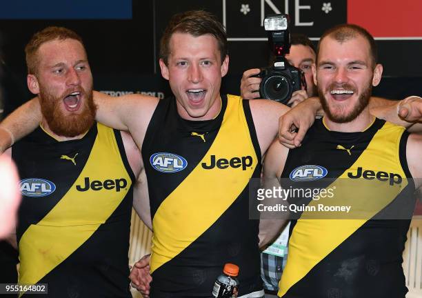Nick Vlastuin, Dylan Grimes and Kamdyn McIntosh of the Tigers sing the song in the rooms after winning the round seven AFL match between the Richmond...