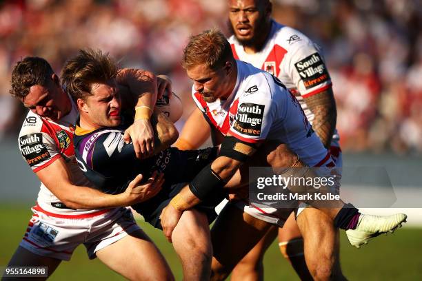 Cameron Munster of the Storm is tackled Matt Duffy and Jack De Belin of the Dragons during the round nine NRL match between the St George Illawarra...