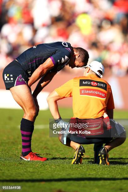 Cameron Smith of the Storm receives attention from the trainer during the round nine NRL match between the St George Illawarra Dragons and the...