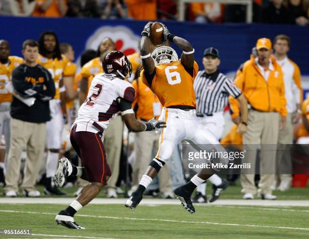 Wide receiver Denarius Moore of the Tennessee Volunteers hauls in a second quarter pass while defensive back Devon Morgan of the Virginia Tech Hokies...