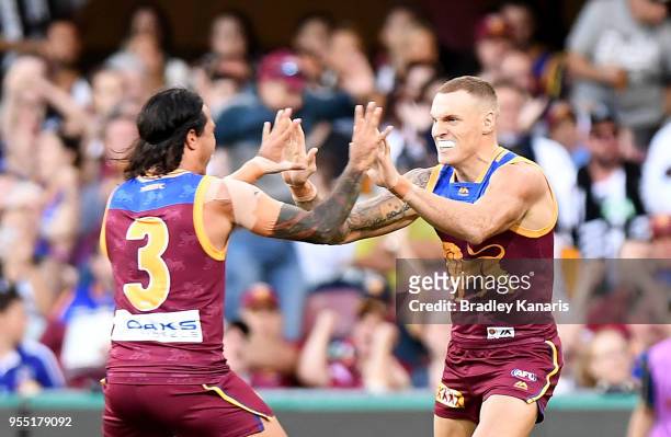 Mitch Robinson of the Lions celebrates scoring a goal with team mate Allen Christensen during the round seven AFL match between the Brisbane Lions...