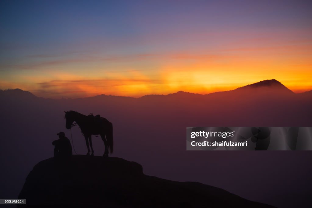Silhouette of unidentified local people or Bromo Horseman at the mountainside of Mount Bromo, Semeru, Tengger National Park, East Java of Indonesia.