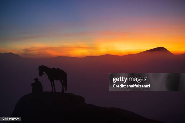 silhouette of unidentified local people or bromo horseman at the mountainside of mount bromo, semeru, tengger national park, east java of indonesia. - bromo horse stock pictures, royalty-free photos & images