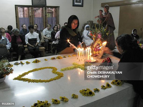 Indian visitors light candles on the grave of Mother Teresa at the Missionaries of Charity in Kolkata on January 1, 2010. Nuns, volunteers and...