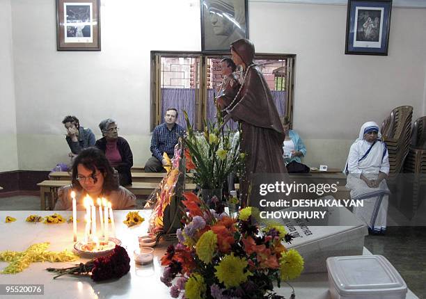 Indian visitors pray over the grave of Mother Teresa at the Missionaries of Charity in Kolkata on January 1, 2010. Nuns, volunteers and visitors took...