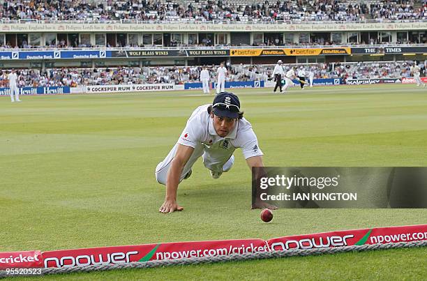 England's Alastair Cook unsuccessfully attempts to stop a ball going for 4 runs off the batting of Australia's Mitchell Johnson during the Australian...