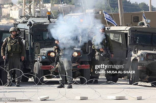 Israeli troops fire tear gas towards Palestinian Fatah supporters during a protest against Israel's controversial separation barrier in the West Bank...