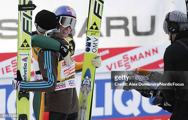 Winner Gregor Schlierenzauer of Austria celebrates with Simon Ammann of Switzerland who placed third during the FIS Ski Jumping World Cup event of...