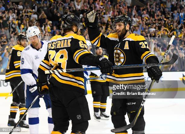 David Pastrnak and Patrice Bergeron of the Boston Bruins celebrate a goal against the Tampa Bay Lightning in Game Four of the Eastern Conference...