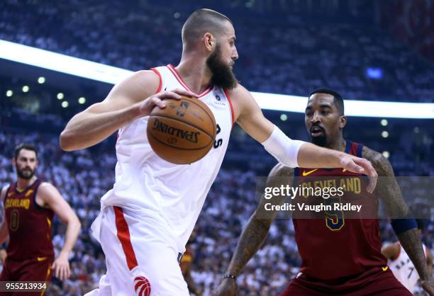 Jonas Valanciunas of the Toronto Raptors dribbles the ball as J.R. Smith of the Cleveland Cavaliers defends in the first half of Game Two of the...