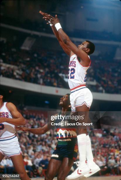 Andrew Toney of the Philadelphia 76ers shoots over T.R.Dunn of the Denver Nuggets during an NBA basketball game circa 1982 at The Spectrum in...