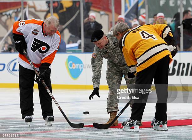 Staff Sergeant Ryan R. LaFrance drops the ceremonial first puck for Bobby Clarke honorary captain of the Philadelphia Flyers and Bobby Orr honorary...