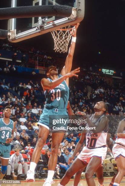 Dell Curry of the Charlotte Hornets lays the ball up over Bernard King of the Washington Bullets during an NBA basketball game circa 1989 at the...