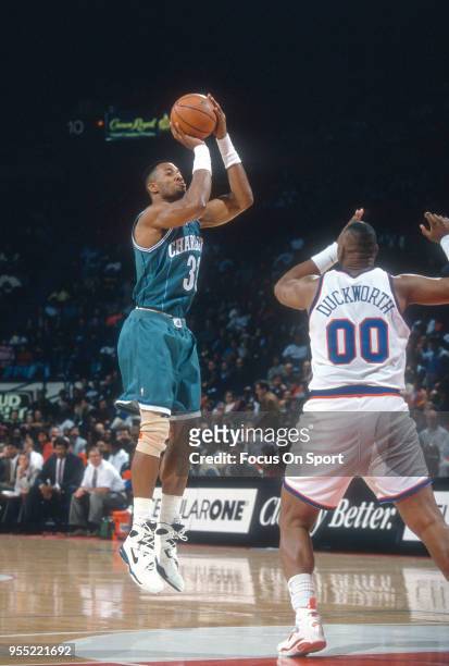 Alonzo Mourning of the Charlotte Hornets shoots over Kevin Duckworth the Washington Bullets during an NBA basketball game circa 1993 at the Capital...