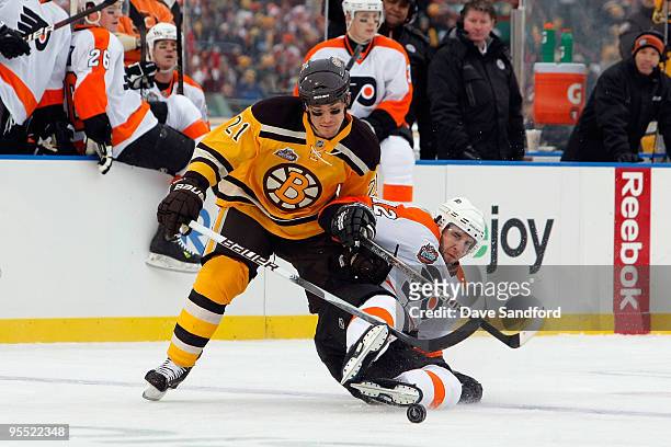 Andrew Ference of the Boston Bruins fights for the puck against Simon Gagne of the Philadelphia Flyers during the 2010 Bridgestone NHL Winter Classic...