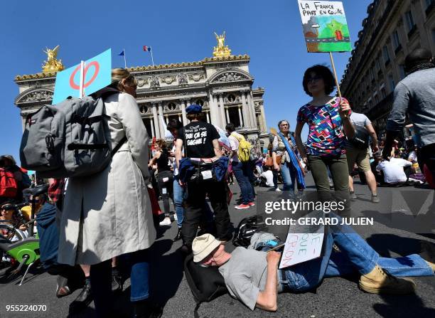 Protesters hold up placards during a rally dubbed as "The Party for Macron" to protest against the policies of the French president on the first...