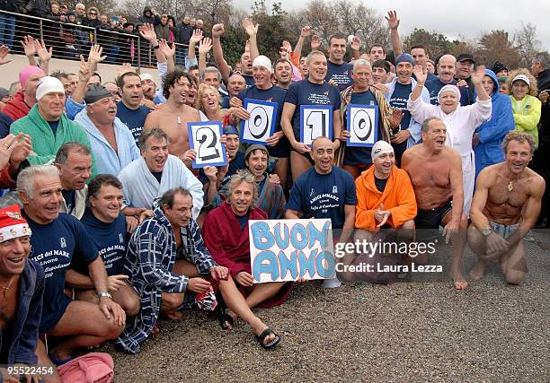 Swimmers take a souvenir picture before dipping into the cold water of the Tyrrhenian Sea during the 'New Year's Dip' on January 1, 2010 in Livorno,...