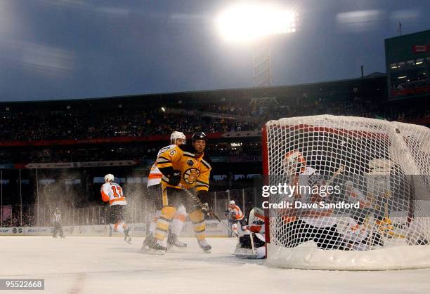 Marco Sturm of the Boston Bruins scores the game-winning goal in overtime to win 2-1 against goalie Michael Leighton and Braydon Coburn of the...