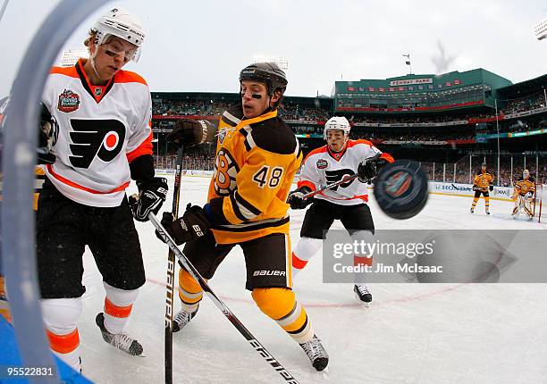 Claude Giroux of the Philadelphia Flyers fights for possession of the puck against Matt Hunwick of the Boston Bruins during the 2010 Bridgestone...