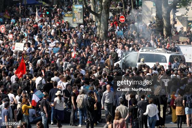 Smoke bomb is thrown into a vandalised Franceinfo media vehicle as thousands gather during a protest dubbed a &quot;Party for Macron&quot; against...